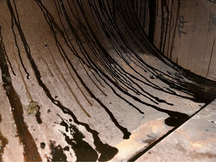 Heavy grease running down the inside of an exhaust duct before cleaning