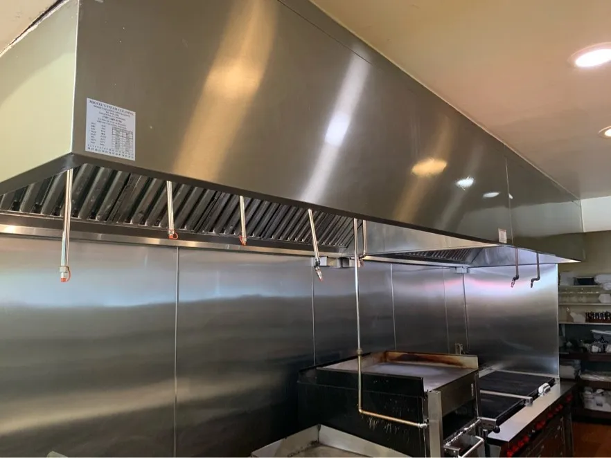 Long stainless restaurant hood over the cook line after cleaning